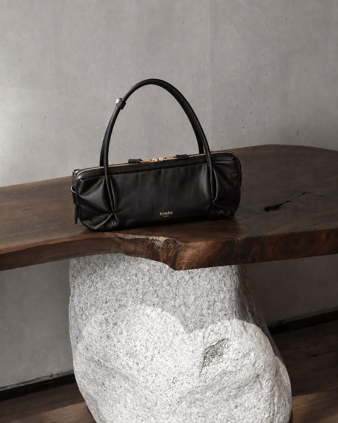 cartera negra de cuero brillante sobre mesa de madera