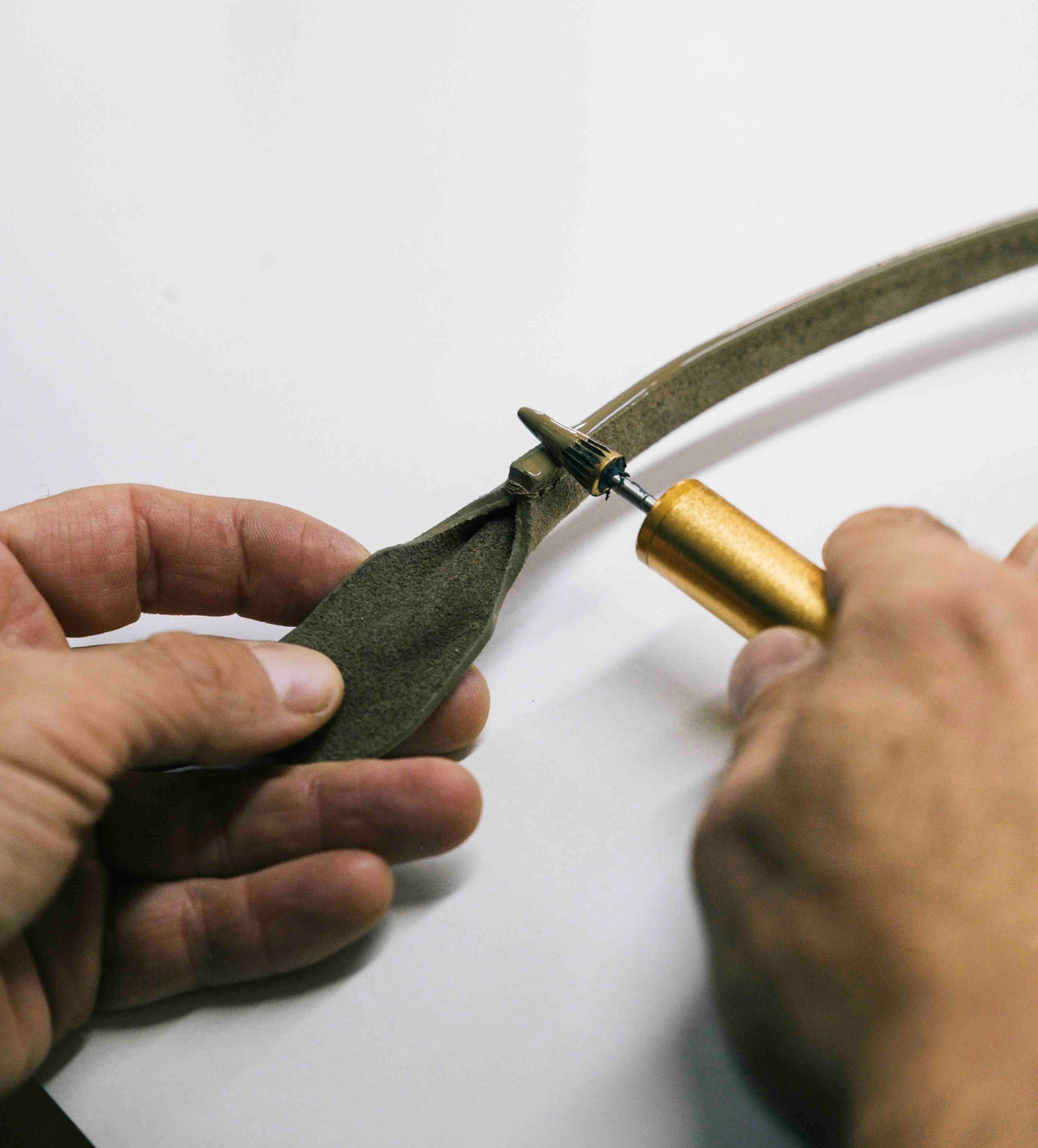 artesano italiano trabajando sobre el asa de la cartera de cuero